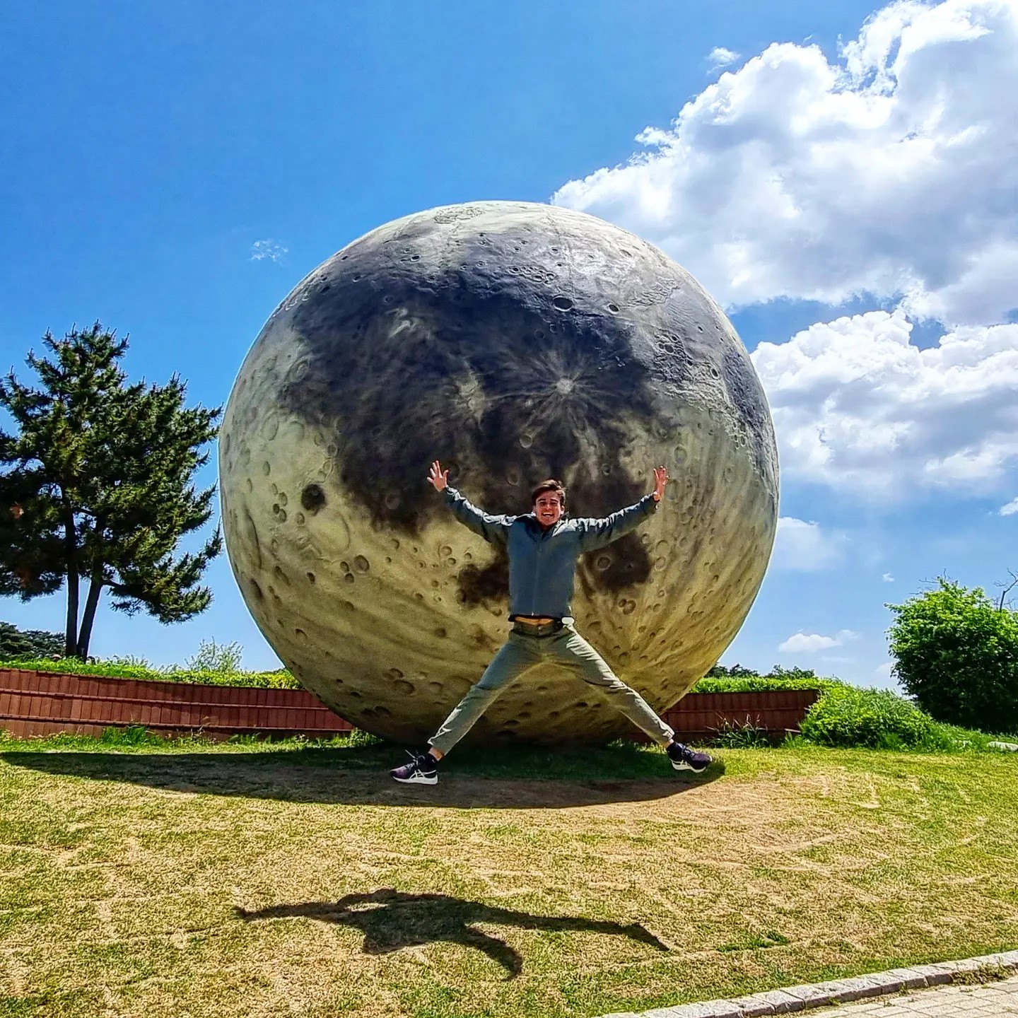 Asensio saltando frente a una escultura gigante de la Luna en Corea del Sur