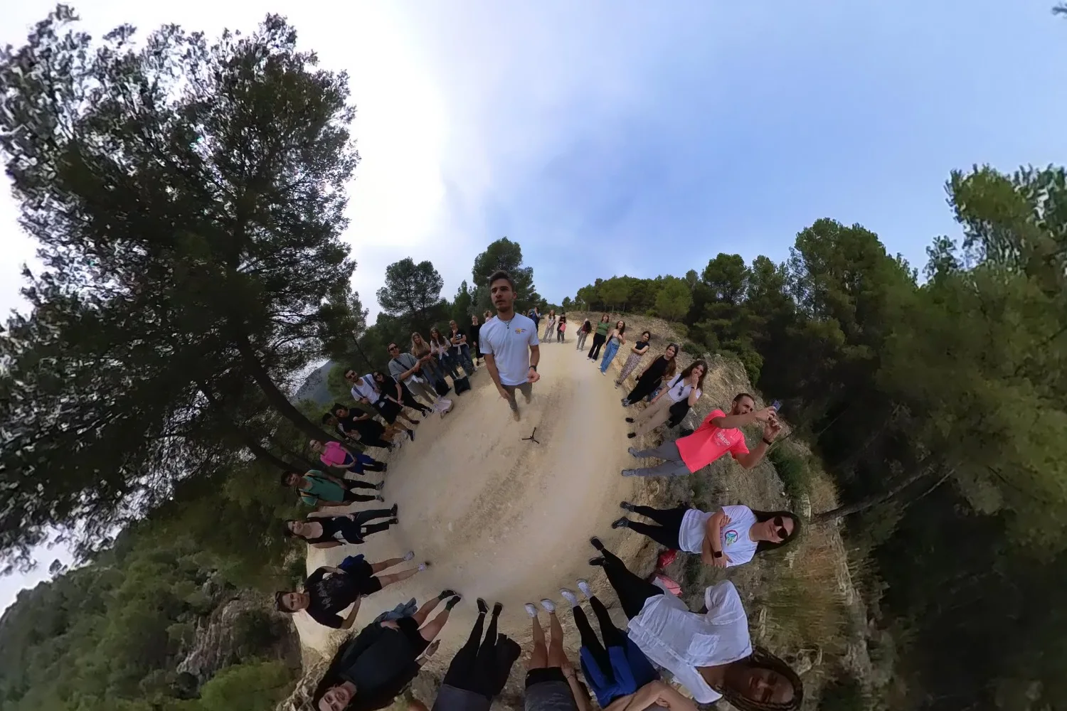 Foto 360° de un encuentro de Murcia Welcomes You: el grupo en círculo sobre un camino entre pinos, con Asensio en el centro